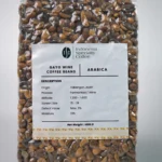 A glass of Gayo Wine Coffee featuring a dark, rich color and a layer of frothy cream, set against a neutral background.