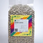 A detailed view of Arabica Aceh Gayo coffee beans, emphasizing their vibrant color and distinct shape.