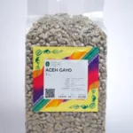 A detailed view of Arabica Aceh Gayo coffee beans, emphasizing their vibrant color and distinct shape.